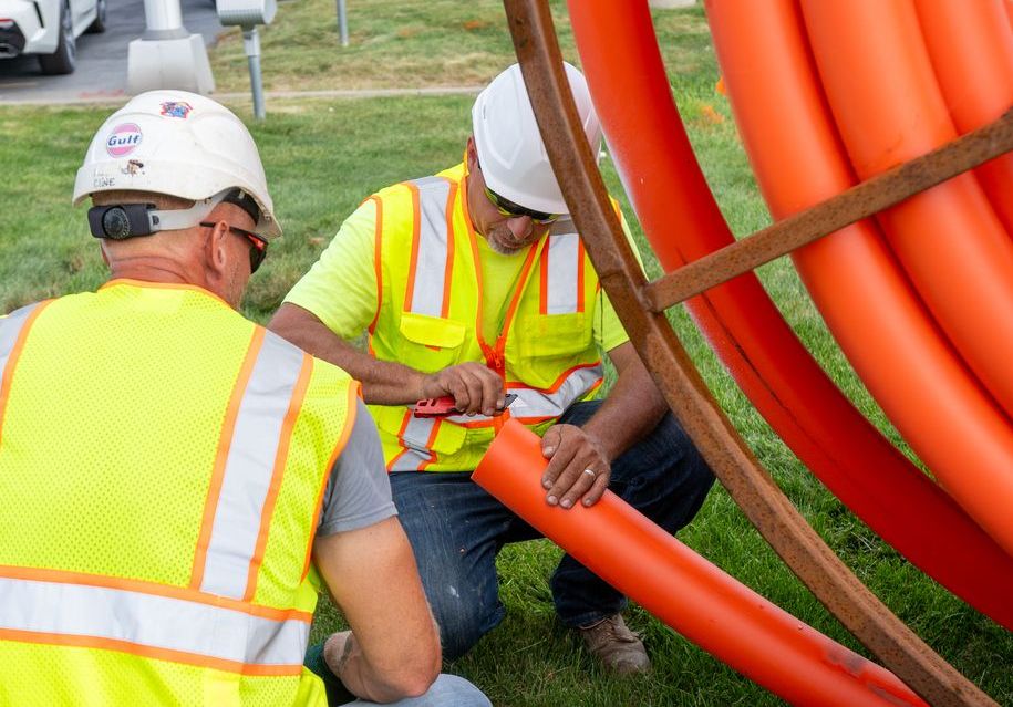 Workers working on wires and tubing.